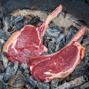 Tomahawk steak caveman-style in het vuur van de kamado