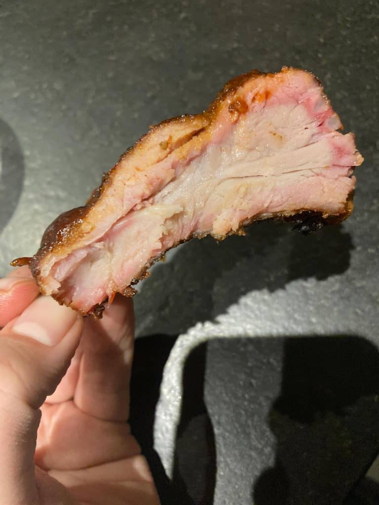 Sparerib in de hand van barbecue marq