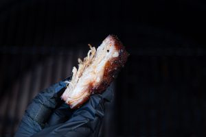 Oosters buikspak langzaam gegaard op de kamado in de handen van marc