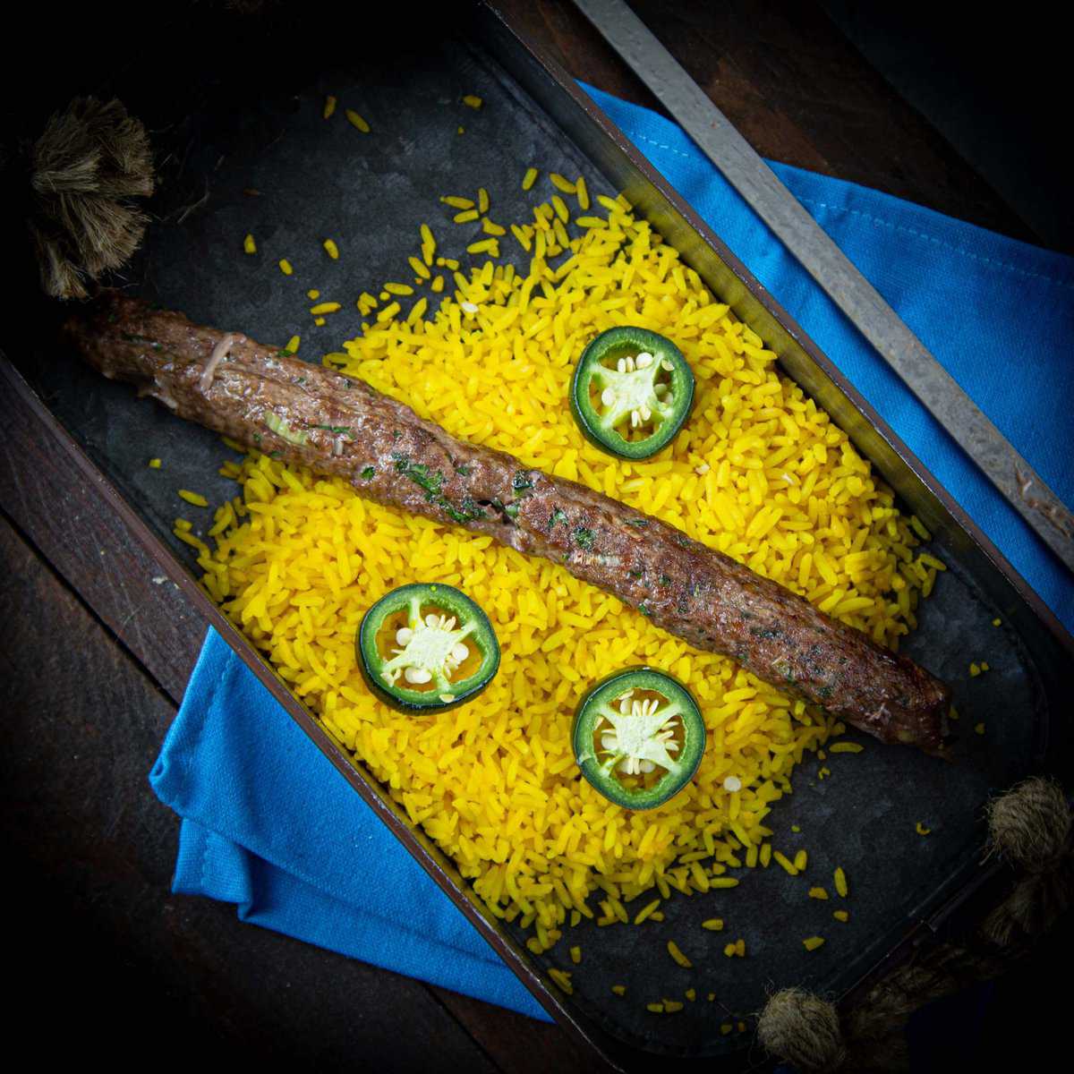 Kebabspies van lamsgehakt met gele rijst op de barbecue